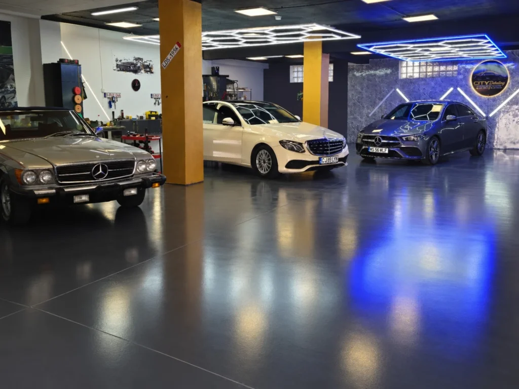 Atelierul City Detailing din Cluj-Napoca, cu trei automobile Mercedes, podea antracit și iluminare profesională