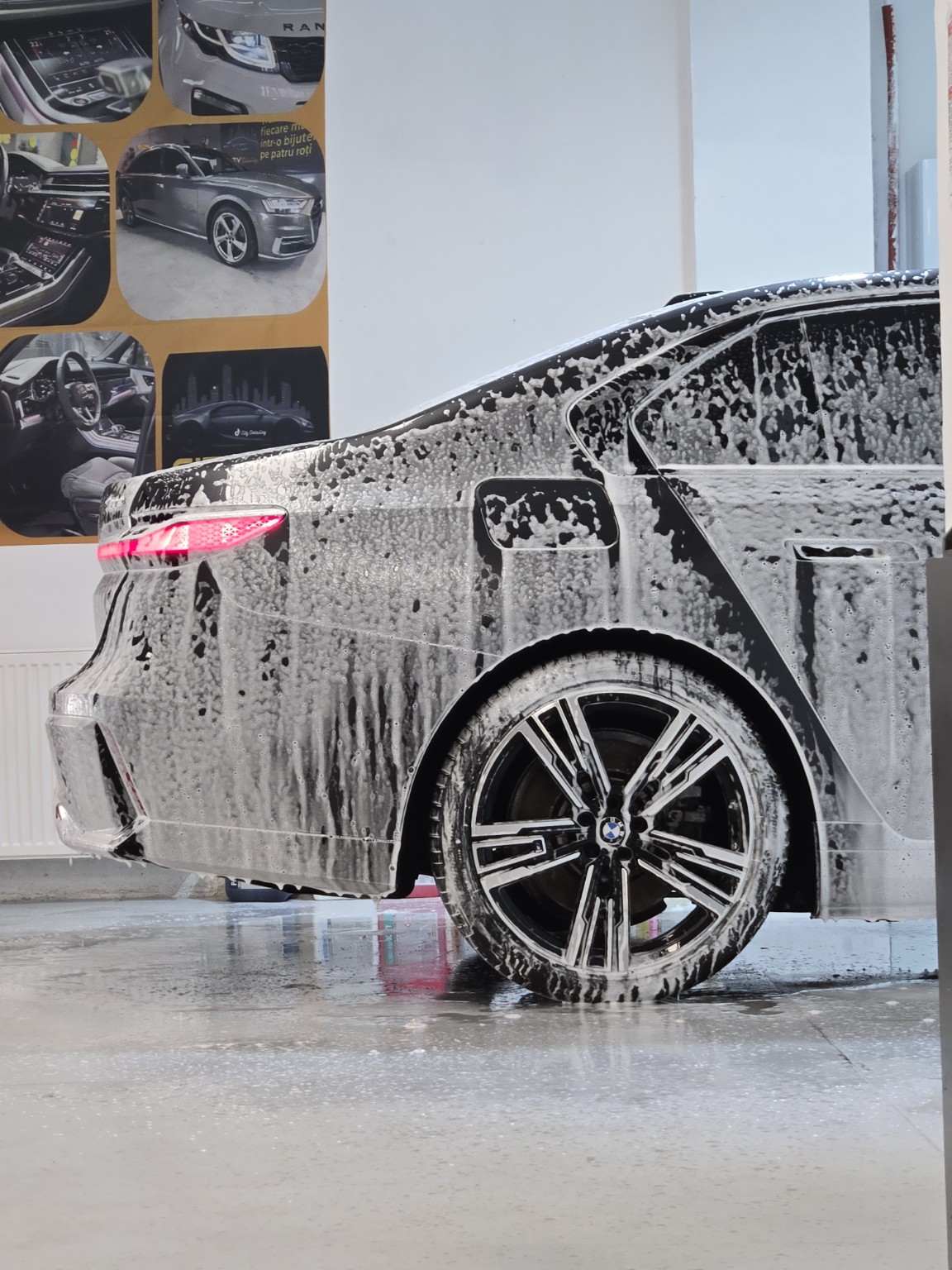 Partea laterală a unui BMW acoperită cu spumă în timpul prespălării la City Detailing